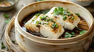 photo of asian steamed sea bass with ginger sauce and chopped onions