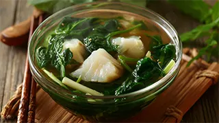 photo of a bowl of clear cod soup with bamboo shoots and spinach