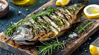 photo of a grilled sea bass slashed and stuffed with herbs